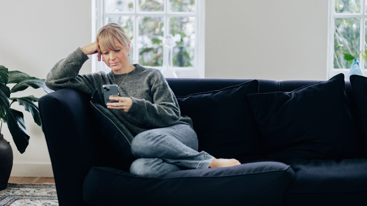 woman on a couch looking at the mobile