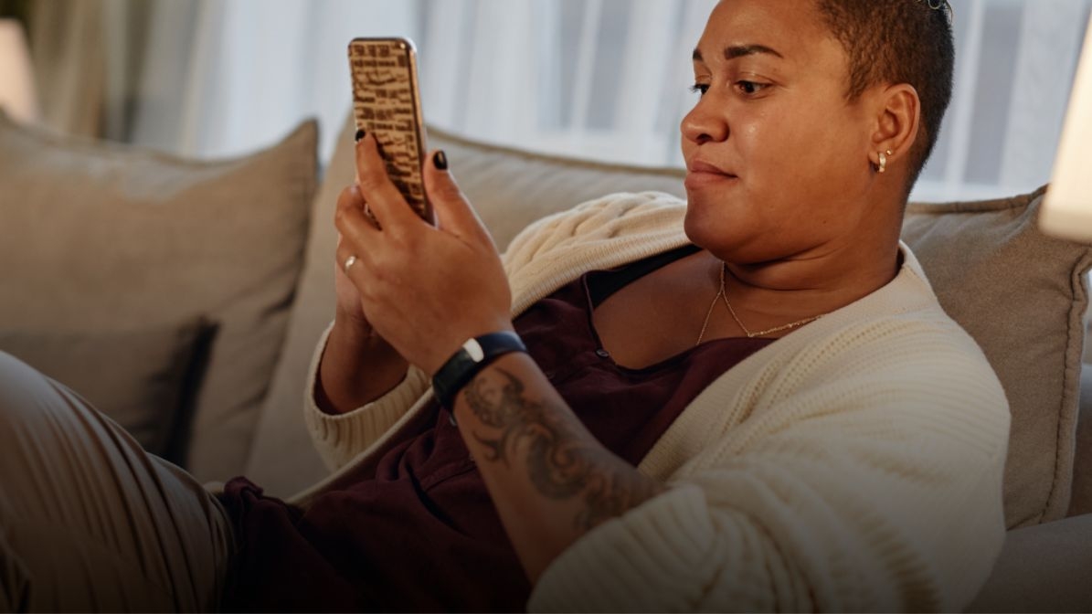 woman looking at mobile in a couch